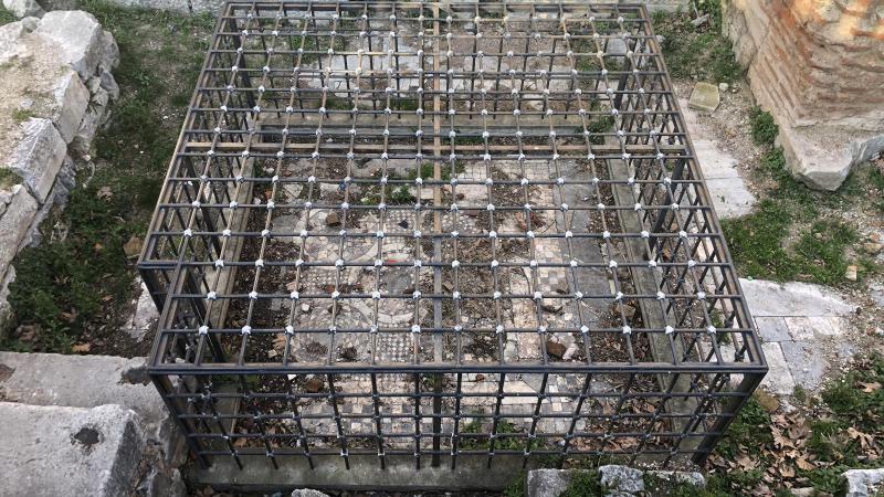 Koruma amaçlı kafese alınan tarihi mozaik çöpten görünmüyor