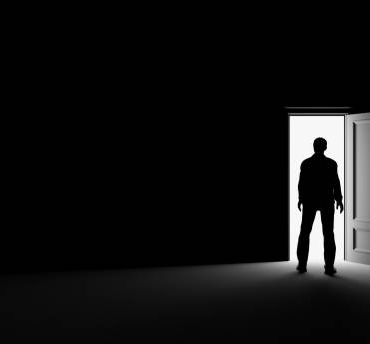 Silhouette of a man standing in a dark room lit by bright light. 3d rendering